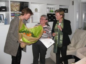 Karin Johansen overrækkes blomster og et hæderslegat af Vibeke From Jeppesen under tilstedeværelse af borgmester Benedikte Kiær